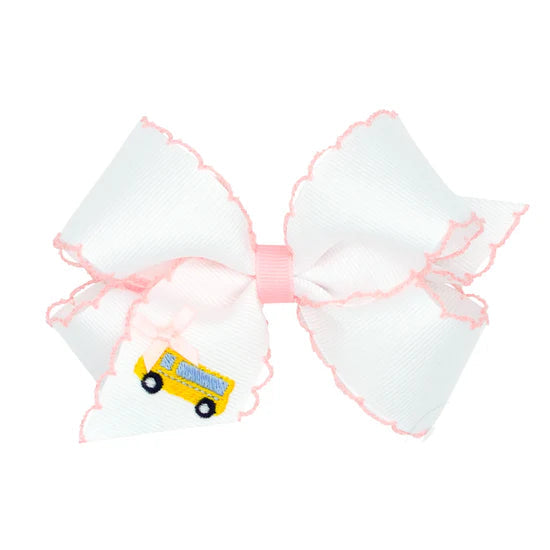 Large white bow with pink trim featuring a small yellow school bus design on a white background.