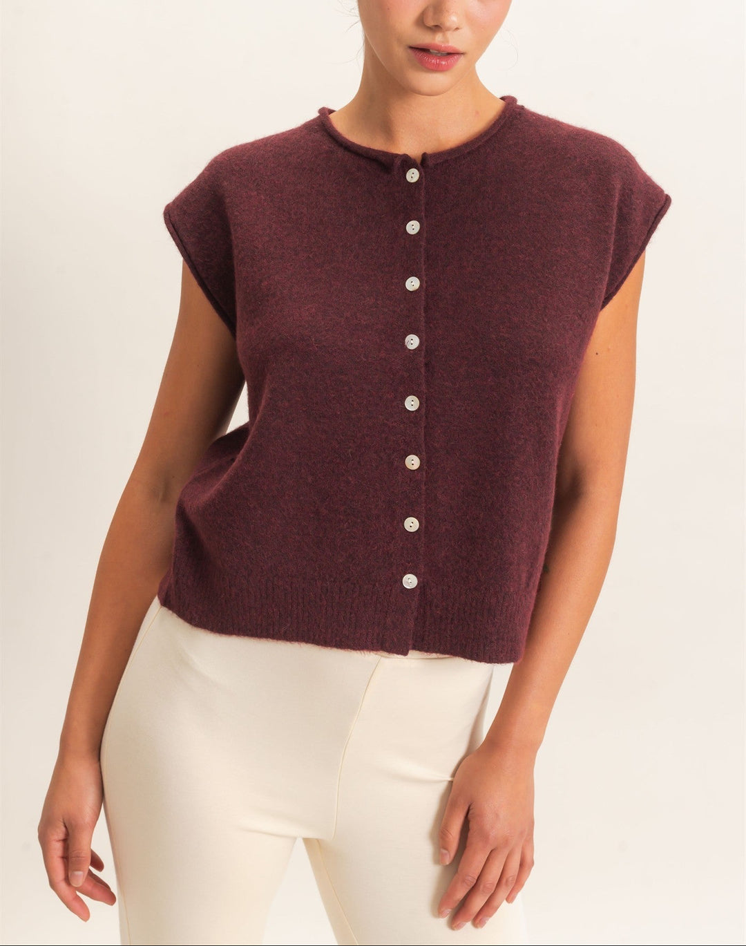 This sleeveless button front sweater vest features a classic rolled crew neckline and a relaxed silhouette, perfect for layering. Crafted with precision, it offers an elevated look with its ribbed hem. Pair it with high-waisted denim and a statement belt for a chic ensemble.
