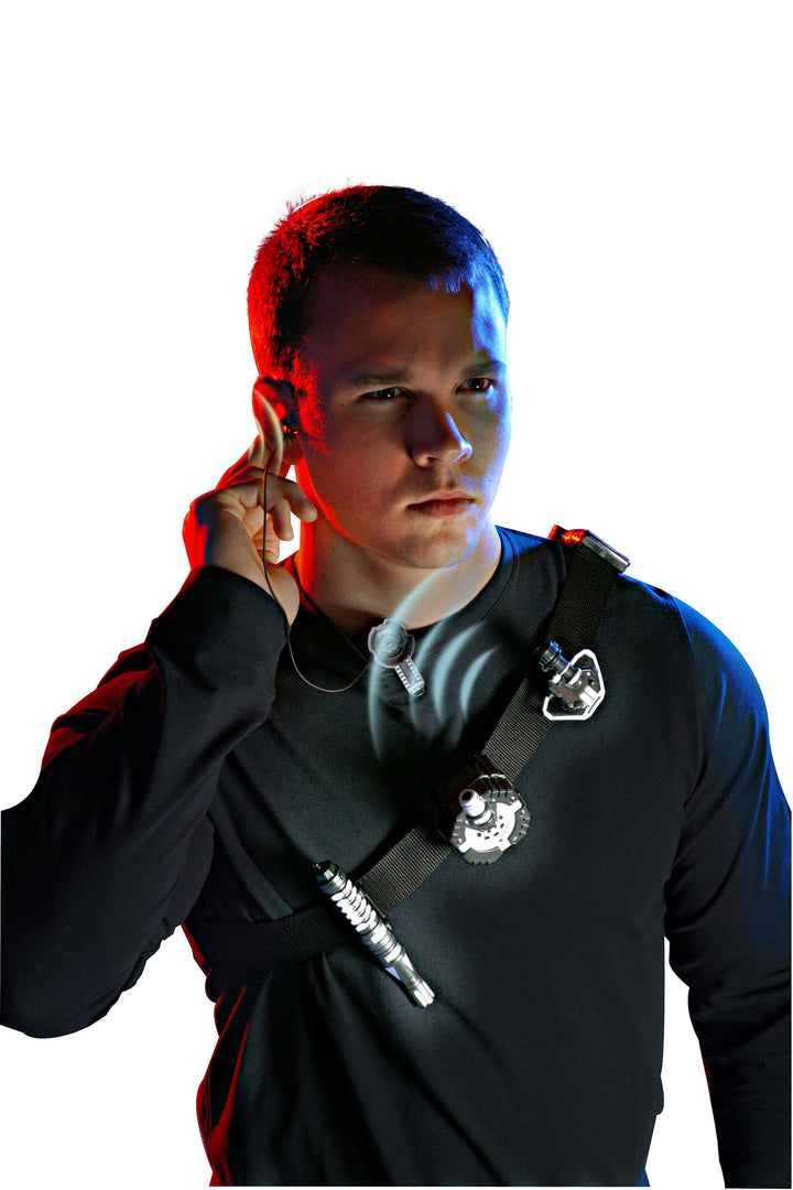 Person with red hair holding a phone, wearing a black jacket with a logo, against a white background