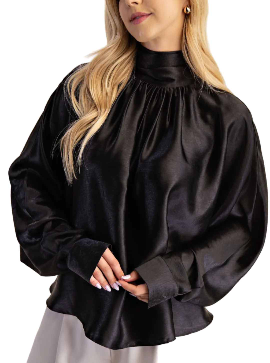 Woman wearing a black blouse with a high collar against a beige background