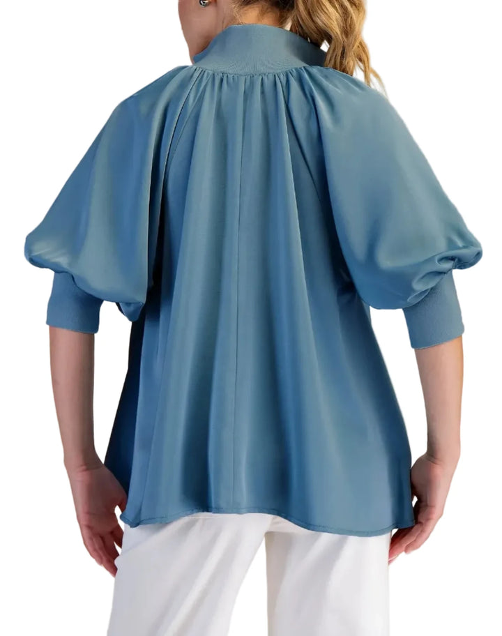 The high neck collar and unique zipper detail add a modern touch, while the loose, oversized fit ensures comfort and style. The puff sleeves create a chic, feminine silhouette. Perfect for both casual and dressy occasions. The smooth satin fabric drapes beautifully, offering a luxurious feel.
