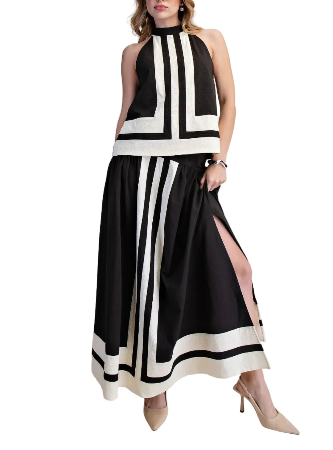 Woman wearing a black and white dress with a slit on a beige background