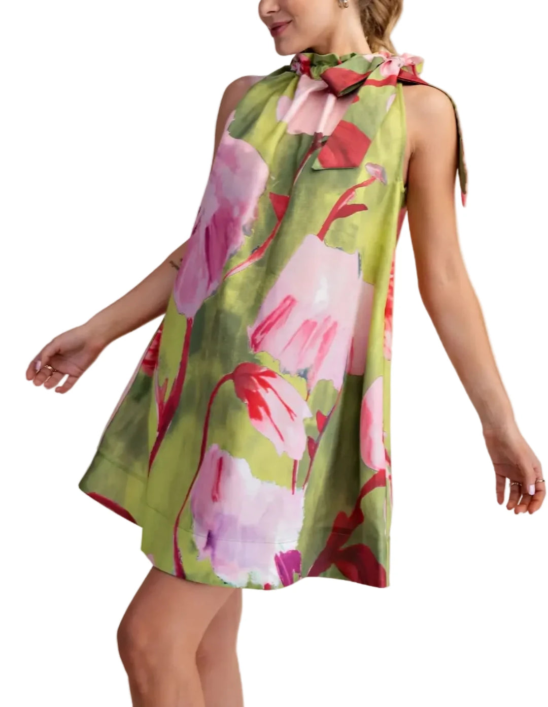 Woman wearing a floral dress with pink and green colors on a beige background