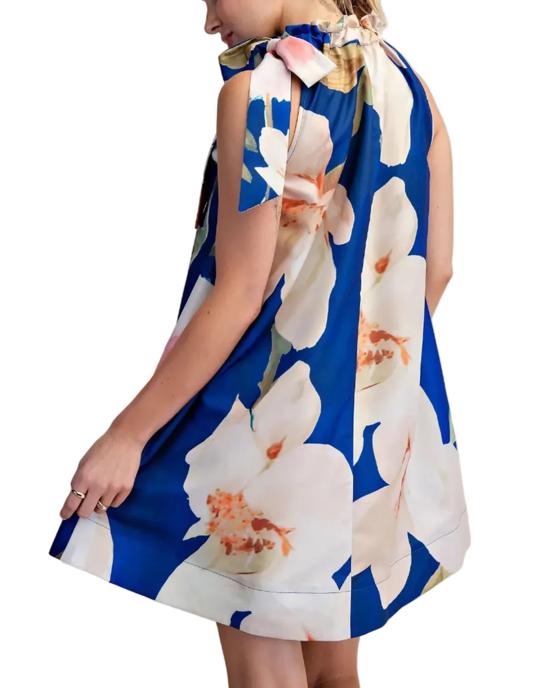 Woman wearing a blue floral dress against a beige background