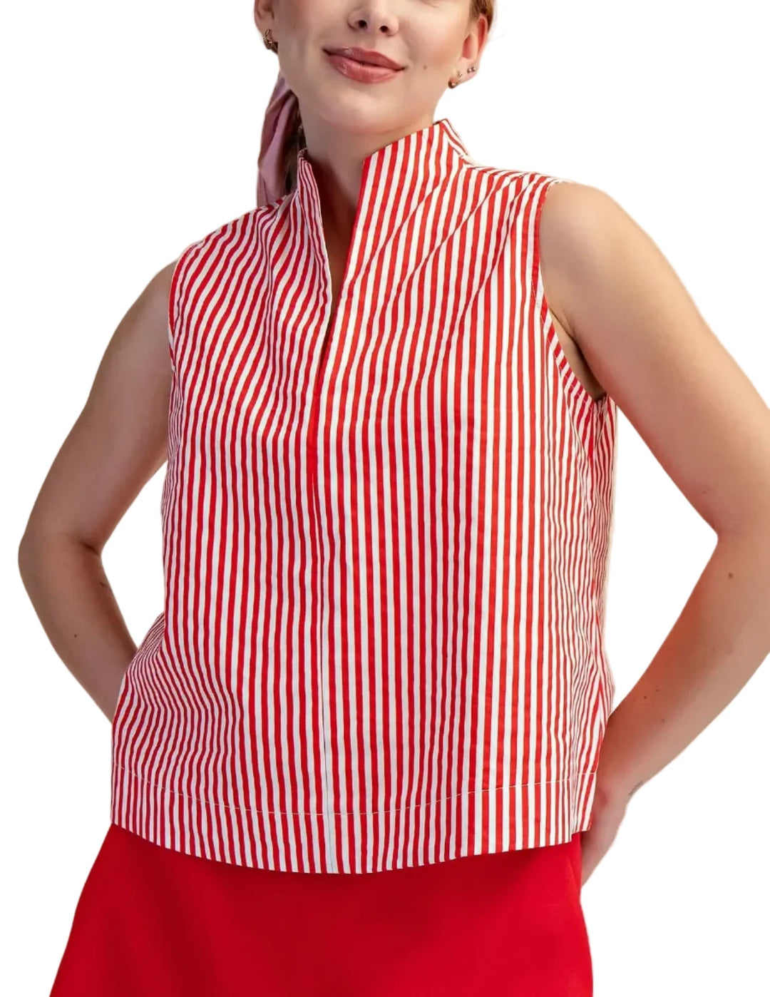 Woman wearing a red and white striped sleeveless top against a beige background