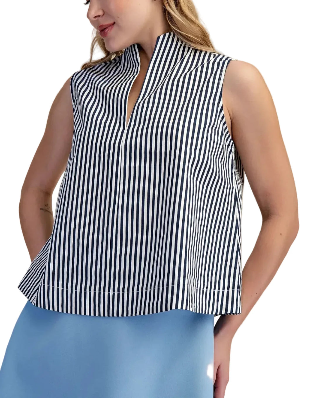 Woman wearing a black and white striped sleeveless top with a beige background