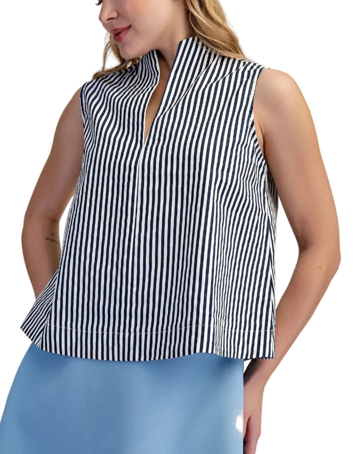 Woman wearing a black and white striped sleeveless top with a beige background