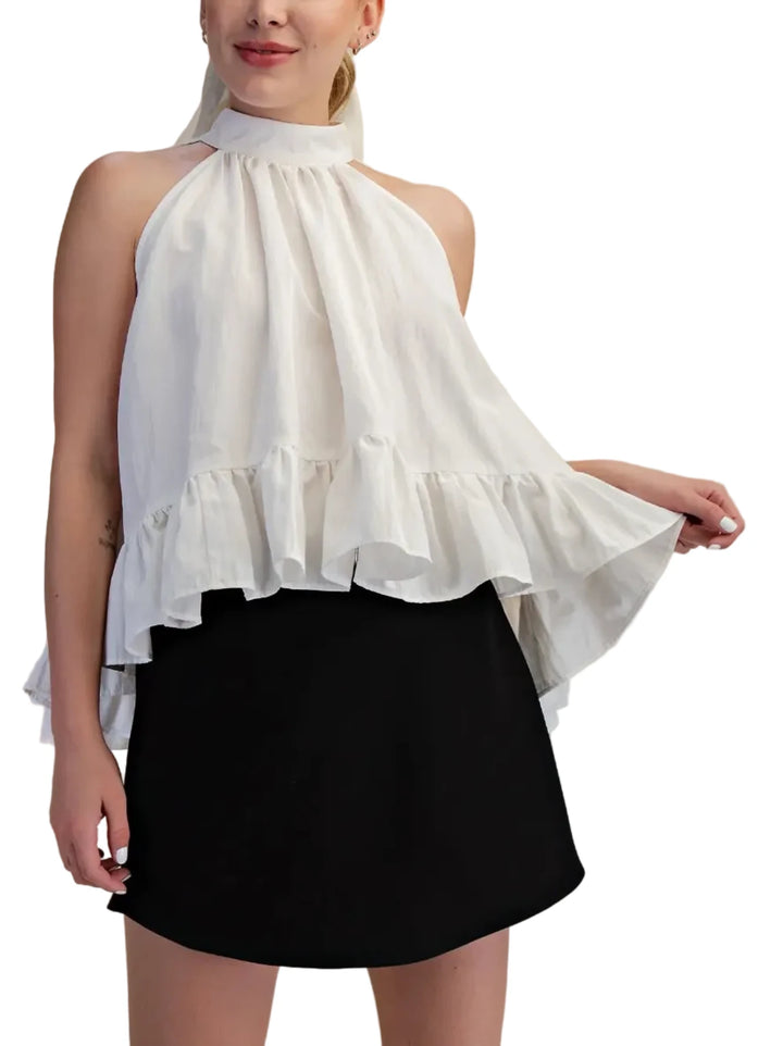 This exquisite halter top is a true embodiment of modern elegance and playful sophistication. Crafted from a lightweight, flowing fabric, it drapes beautifully, creating a flattering silhouette that is both airy and romantic. The halter neckline and the tie neck, a timeless classic, is elevated with a dramatic ruffled collar that frames the face and adds a touch of romantic flair. The voluminous, tiered ruffle detailing cascades down the bodice and flares out at the hem, creating a dynamic and eye-catching 