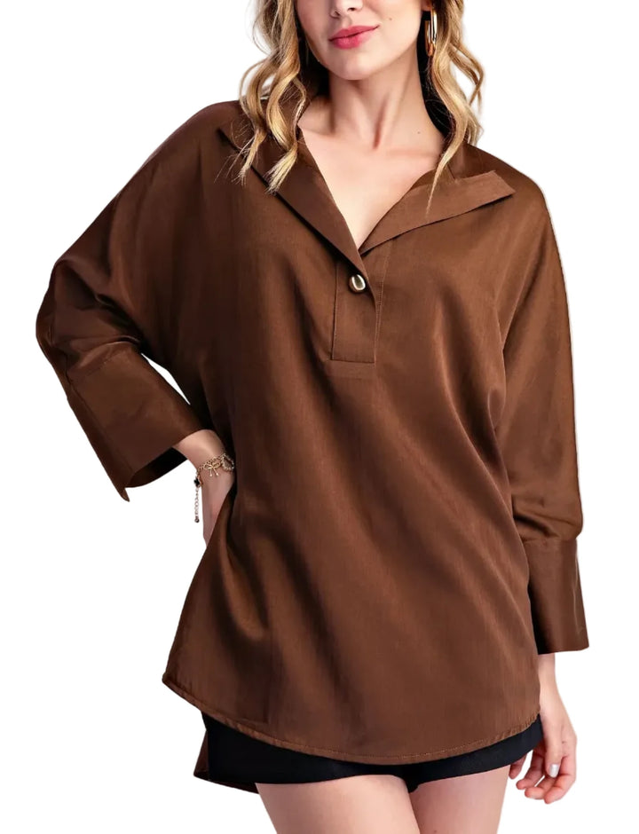 Elevate your casual style with this chic collared shirt blouse. Crafted from a lightweight, breathable fabric with a subtle sheen, this top offers a sophisticated take on a classic shirt. The relaxed fit drapes beautifully, providing comfort and effortless style. Featuring a unique collar with a single, elegant gold-tone button closure at the placket, it adds a touch of refined detail. The long sleeves are finished with neat cuffs, and the curved hemline creates a flattering silhouette. Perfect for pairing 