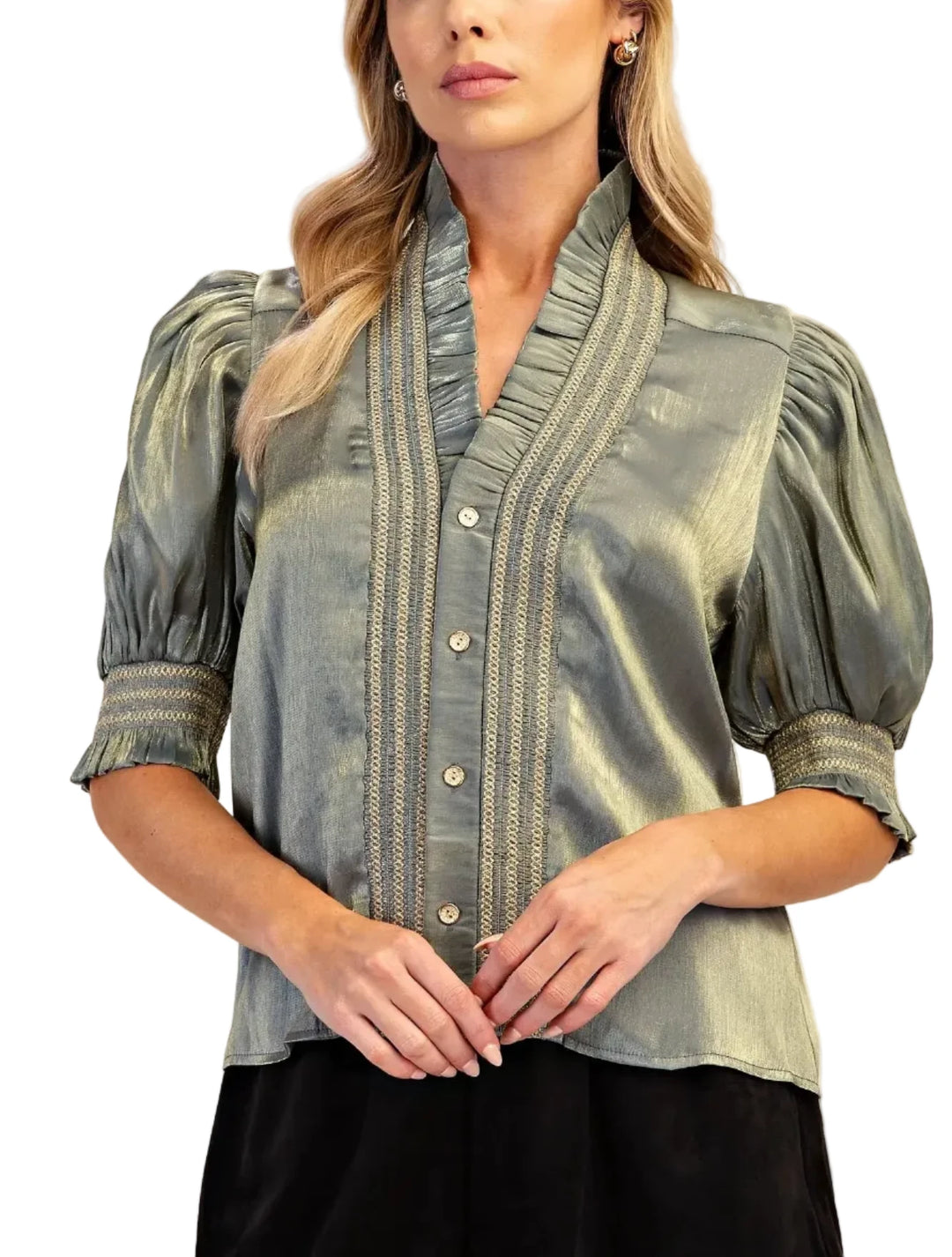 A woman wearing a shimmering sage green satin blouse with puff sleeves, a high ruffled collar, and vertical embroidered detailing on the front, paired with a black skirt against a neutral beige background.