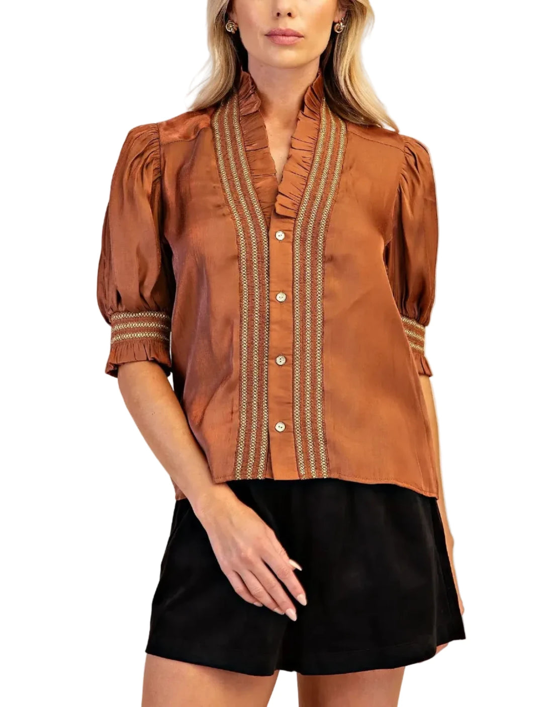 A woman modeling a brown short-sleeve blouse with vertical striped button placket and cuffs, paired with black shorts, against a plain beige studio background.