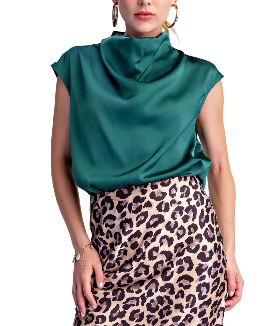 A woman modeling a satin-like teal cowl-neck top paired with a leopard-print skirt, against a plain light beige studio background.