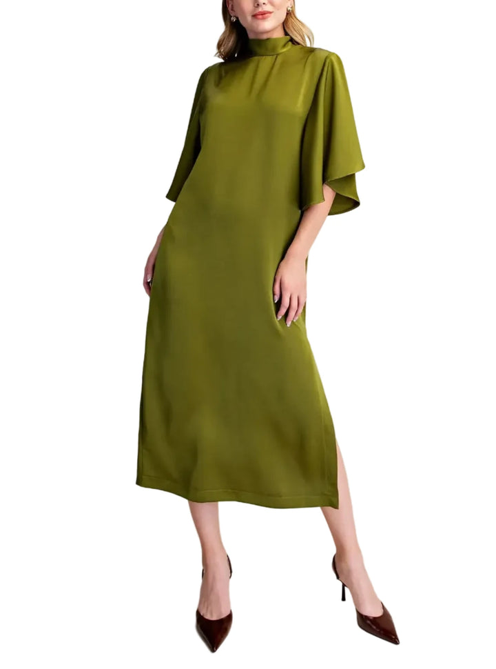 A woman models a high-neck, olive green midi dress with wide, draped half sleeves and a side slit, paired with dark brown pointed-toe heels against a plain beige studio background.