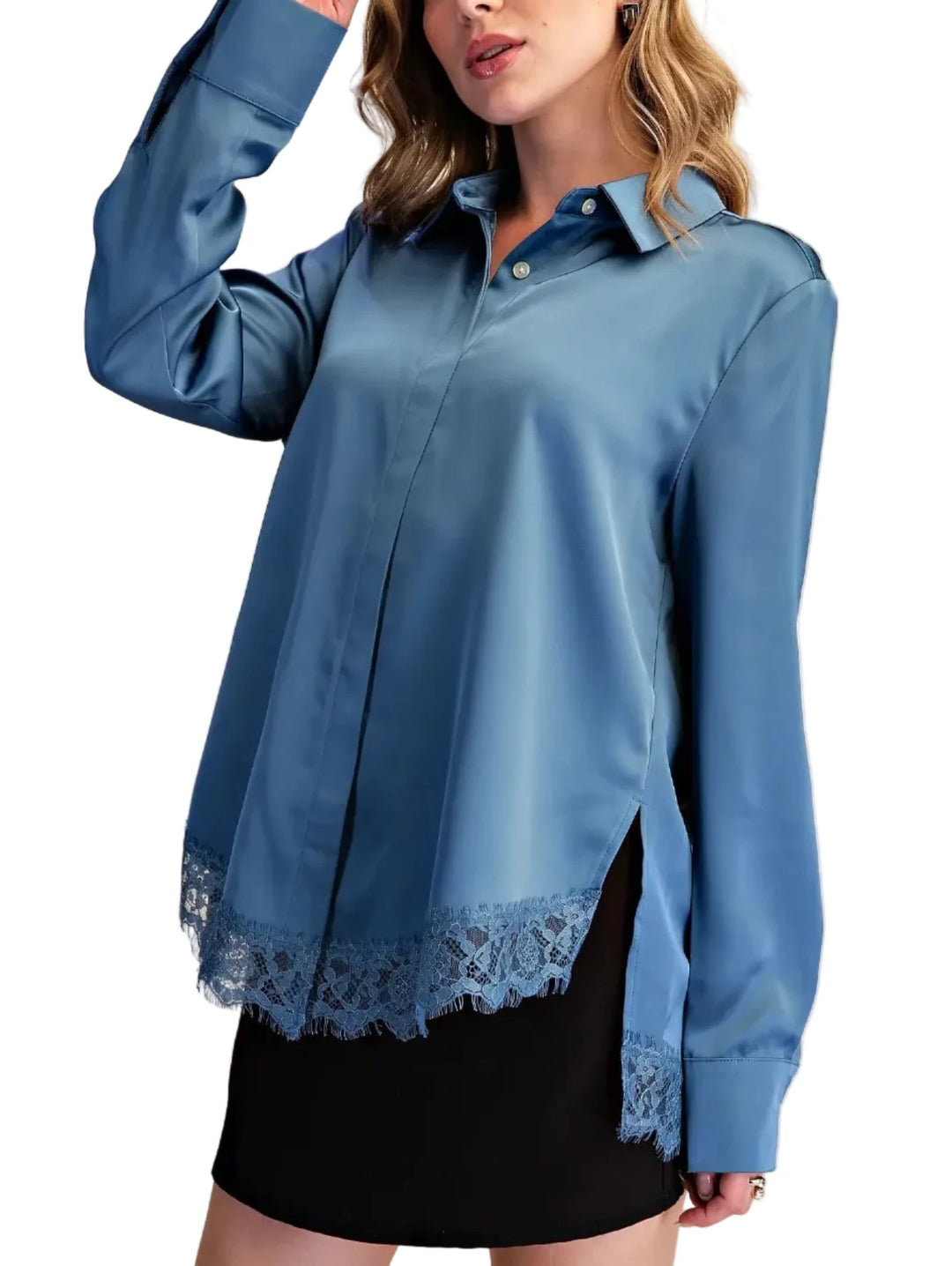 A woman wearing a blue satin-like button-up blouse with lace trim at the hem and cuffs, paired with a black skirt, against a plain beige studio background.