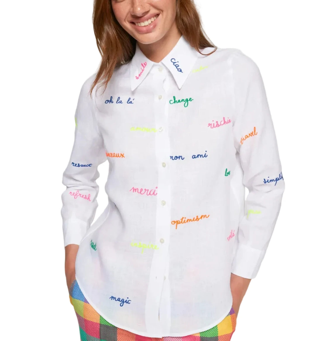 White shirt with embroidered words in fluorescent colors on the front and sleeves. Features a classic shirt collar, button-front closure, and long sleeves. Rounded hem. 
