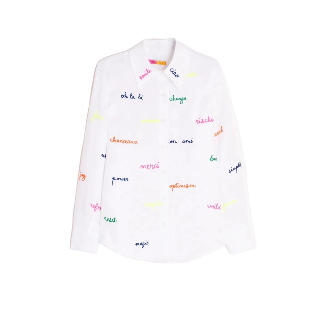 White shirt with embroidered words in fluorescent colors on the front and sleeves. Features a classic shirt collar, button-front closure, and long sleeves. Rounded hem. 
