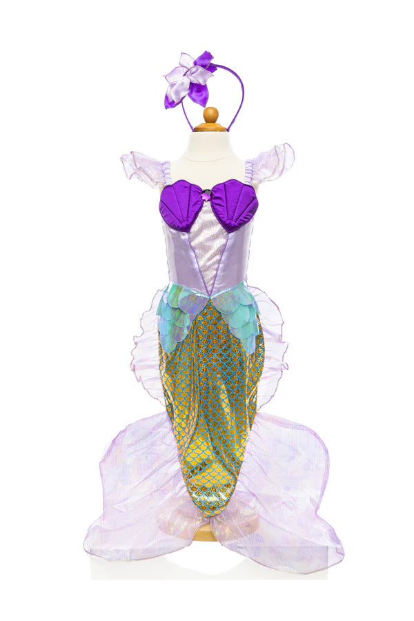 This little Mermaid is set for an underwater adventure! This dress boasts high-quality fabrics with gorgeous lilac, purple, gold, and holographic sea blue colours. It’s very comfortable and even more size flexible with a fully ruched and stretchy top on the backside. The satin bodice features purple shells, a purple gem, lovely shimmery organza sleeves, and a gorgeous sparkly inset. The skirt is shaped like a tail and it's accented with metallic scale print and edged with crystal organza tins and shimmery s