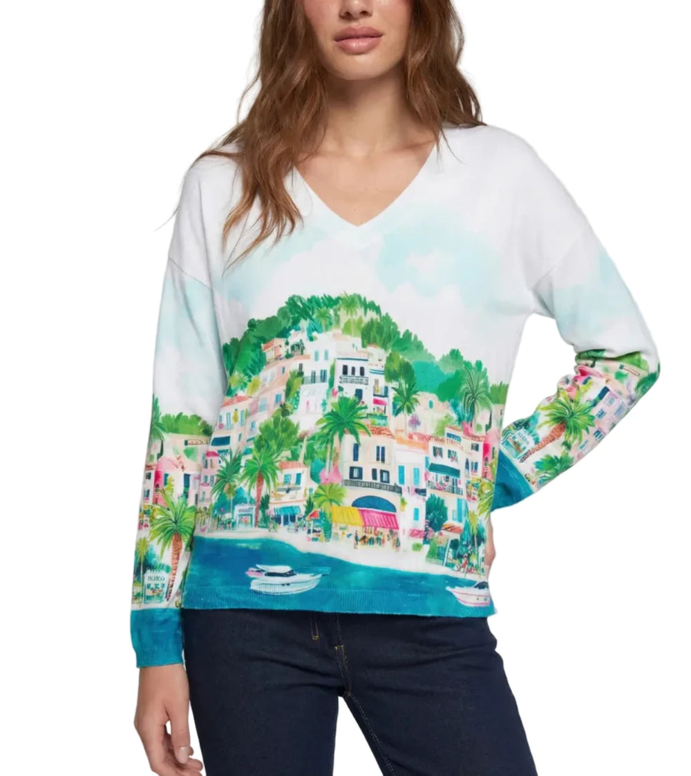 Woman wearing a colorful sweater with a scenic print on a plain background