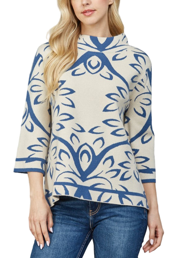 Woman wearing a blue and white patterned top against a gray background