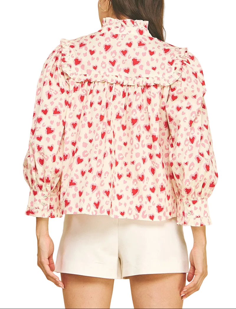 Spread the love with this charming Valerie Heart Pattern Top! Featuring an adorable heart print throughout, this playful piece combines romantic style with practical comfort. The button-down front makes dressing a breeze, while voluminous balloon sleeves add a whimsical touch. Delicate ruffle detailing frames the neckline and cuffs for extra feminine flair. Perfect for date nights, casual outings, or whenever you want to wear your heart on your sleeve—literally!