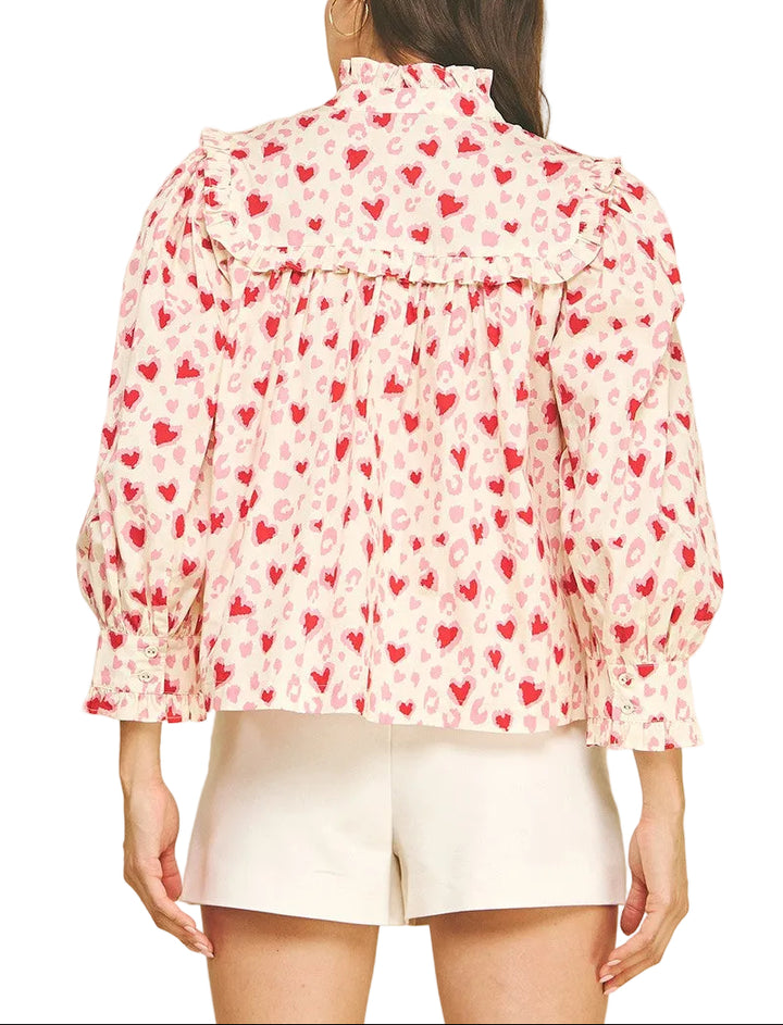 Spread the love with this charming Valerie Heart Pattern Top! Featuring an adorable heart print throughout, this playful piece combines romantic style with practical comfort. The button-down front makes dressing a breeze, while voluminous balloon sleeves add a whimsical touch. Delicate ruffle detailing frames the neckline and cuffs for extra feminine flair. Perfect for date nights, casual outings, or whenever you want to wear your heart on your sleeve—literally!