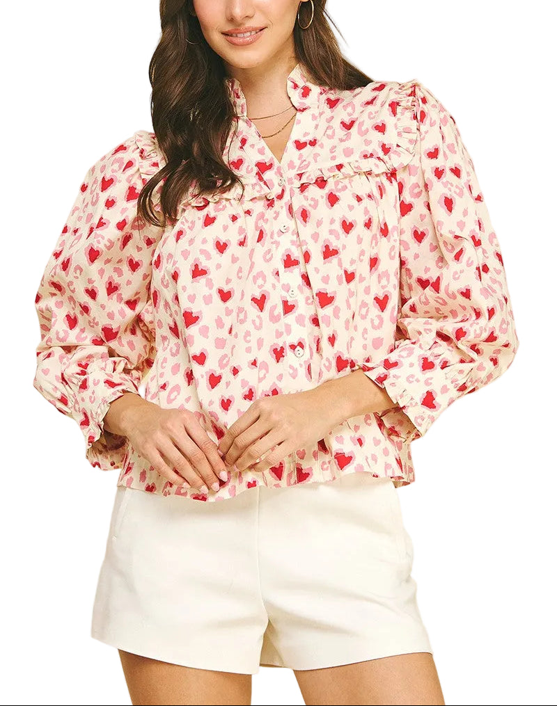 Spread the love with this charming Valerie Heart Pattern Top! Featuring an adorable heart print throughout, this playful piece combines romantic style with practical comfort. The button-down front makes dressing a breeze, while voluminous balloon sleeves add a whimsical touch. Delicate ruffle detailing frames the neckline and cuffs for extra feminine flair. Perfect for date nights, casual outings, or whenever you want to wear your heart on your sleeve—literally!