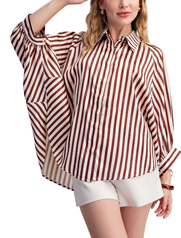 Elevate your wardrobe with this striking white striped shirt. Designed with a relaxed, oversized silhouette and voluminous long sleeves that gather at the cuff, this top offers both comfort and sophisticated style. The classic button-up front and crisp collar add a touch of timeless elegance, making it a versatile piece for any occasion. Crafted from a smooth, flowing fabric, this shirt drapes beautifully, creating a flattering and fashionable look. 