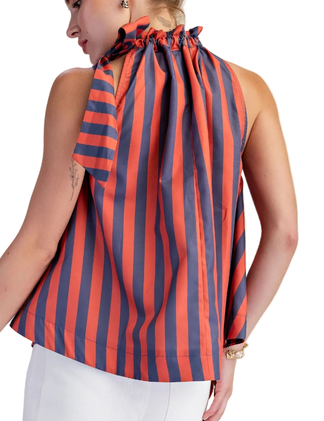 Make a vibrant statement with this eye-catching sleeveless top, designed for the modern woman who loves to stand out. Featuring a bold, vertical stripe pattern in a striking combination of pop color and deep soft color, this halter-neck blouse is sure to turn heads. The playful ruffled neckline artfully gathers into a chic bow at the front, adding a touch of feminine charm and sophistication. 