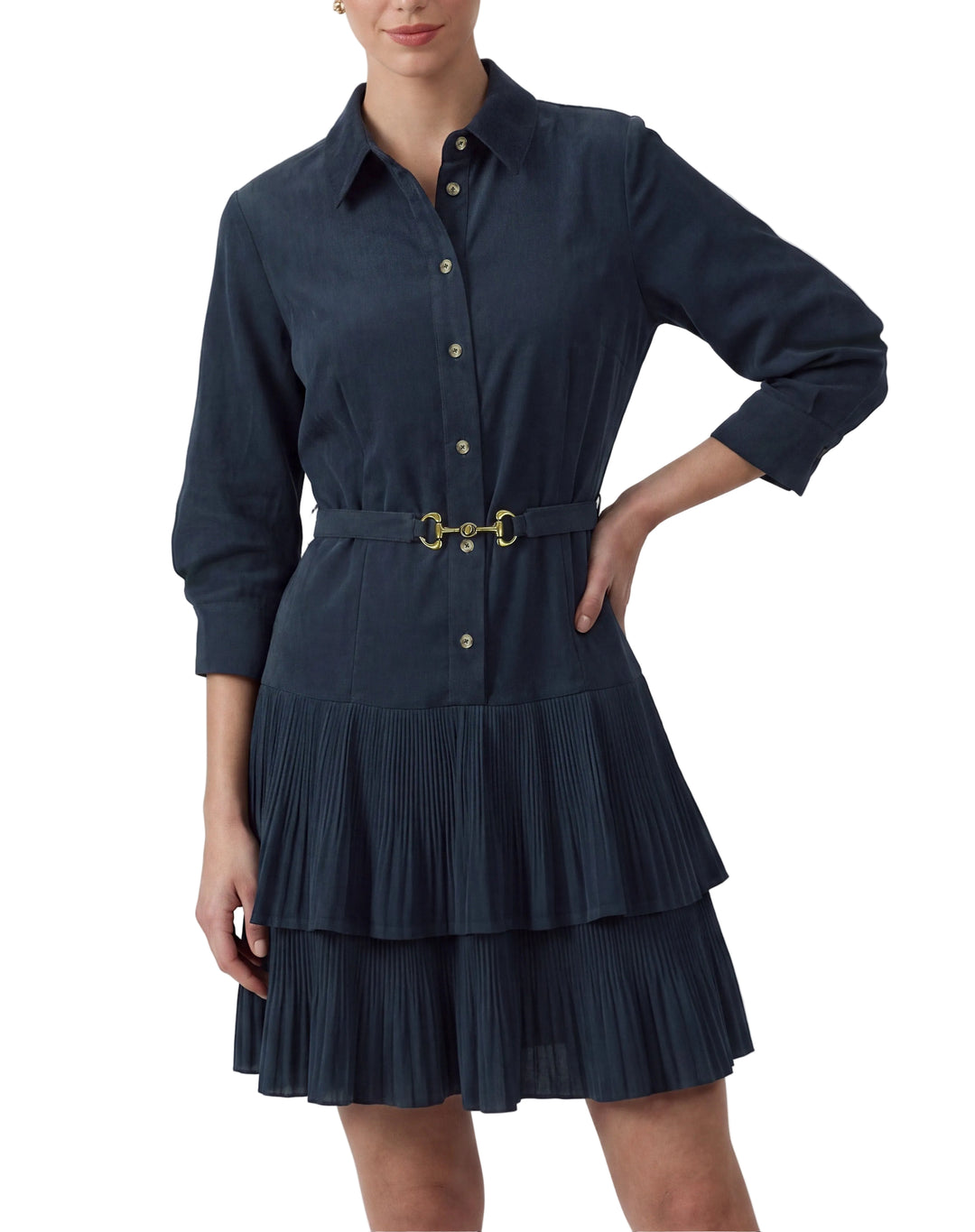A woman modeling a dark navy blue shirt dress with a matching belt featuring a gold buckle, set against a plain light gray studio background.