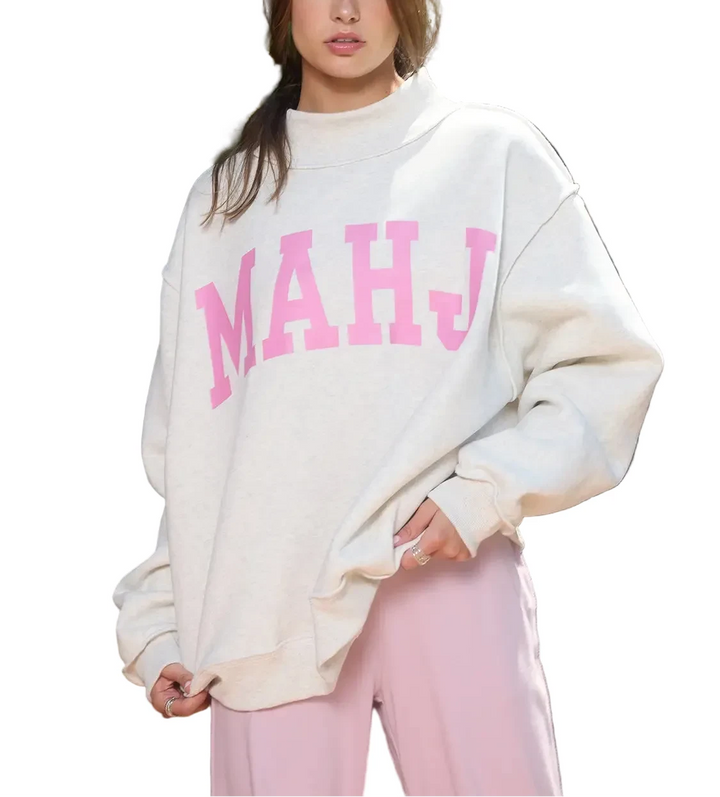 Woman wearing a white sweater with &