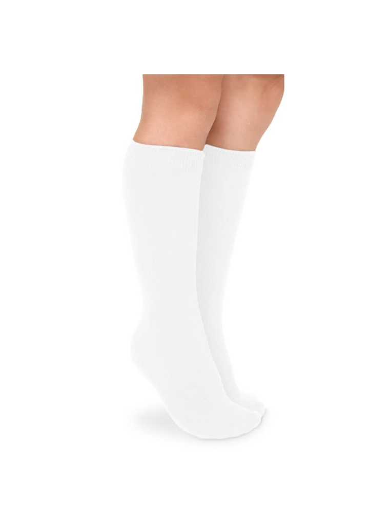 A pair of white knee-high socks worn on a model&