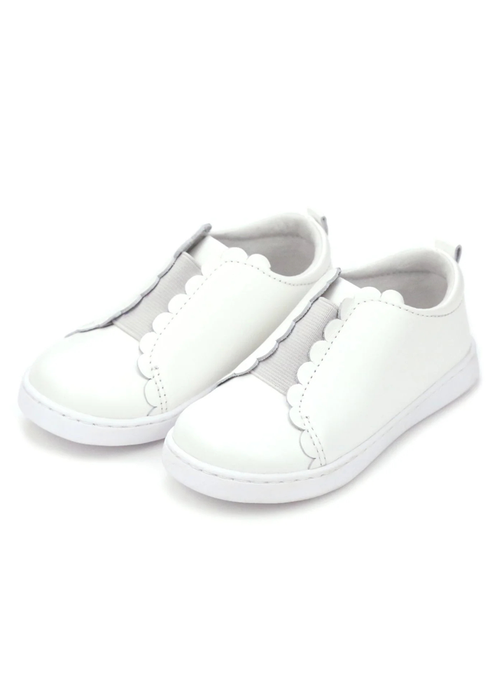 Scalloped and sweet, sister to the Caroline, the Phoebe is the first slip on sneaker in our collection. We love the matching elastic for a semi-sporty look; Phoebe comes with a leather sock bed with memory foam for greater breathability, durability, and comfort as leather conforms to the shape of the foot.