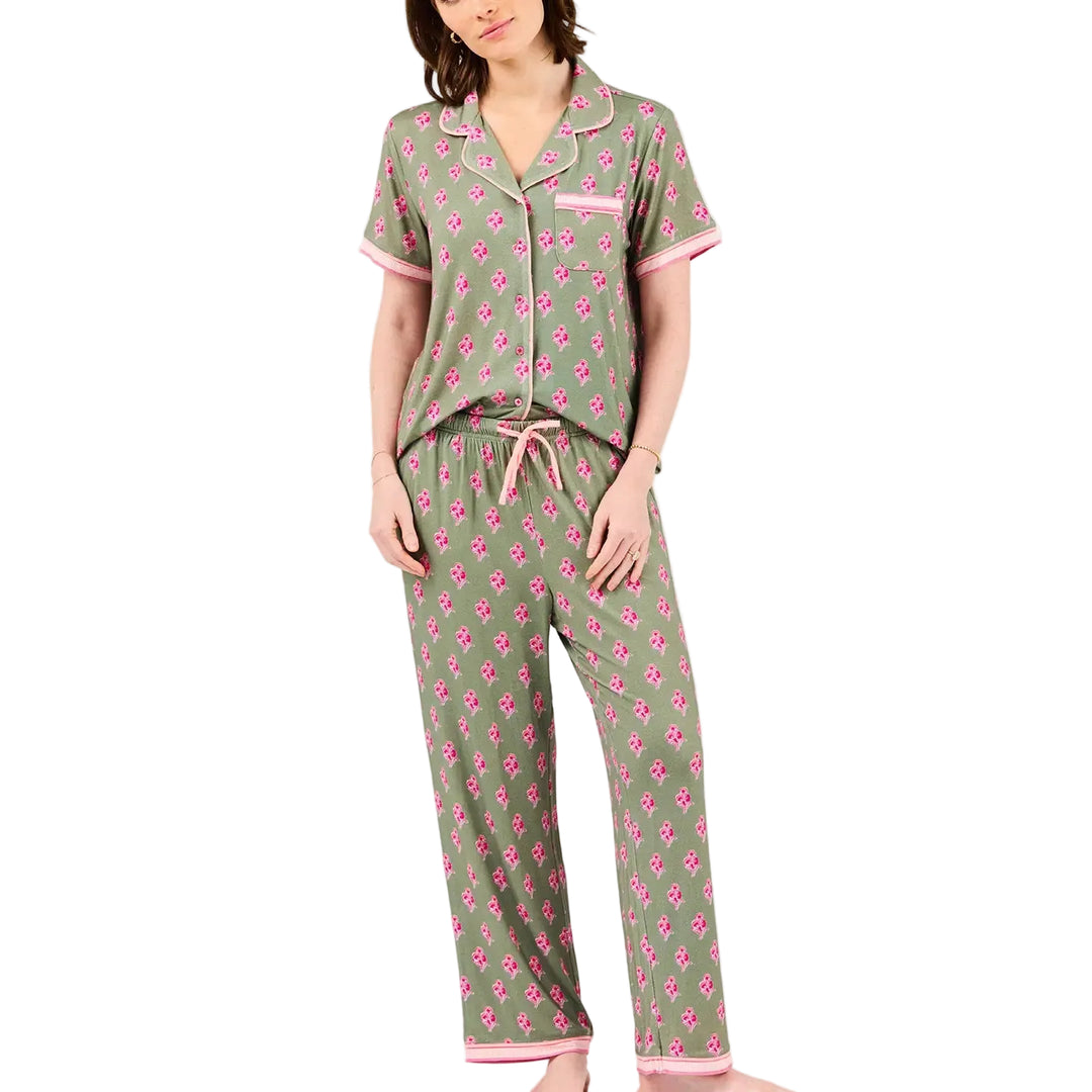 Woman wearing a green and pink floral pajama set on a white background