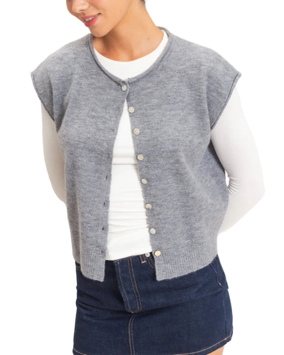 This sleeveless button front sweater vest features a classic rolled crew neckline and a relaxed silhouette, perfect for layering. Crafted with precision, it offers an elevated look with its ribbed hem. Pair it with high-waisted denim and a statement belt for a chic ensemble.
