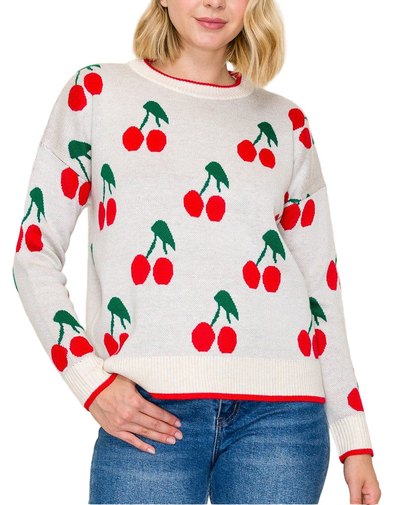 Woman wearing a sweater with cherry pattern against a plain background
