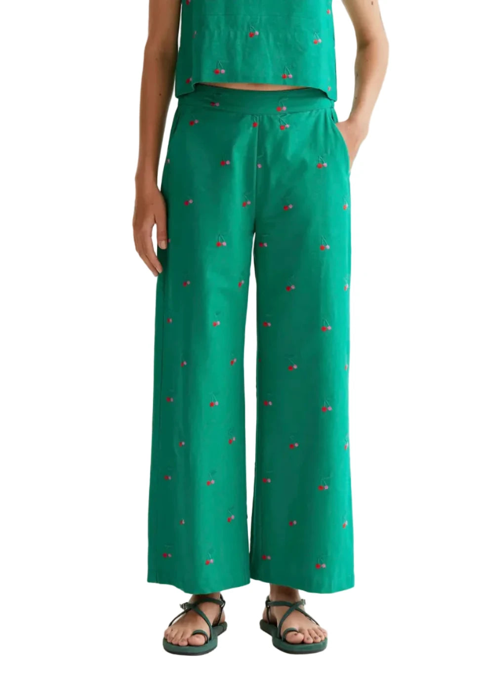 Green trousers made from 100% cotton with a green cherry print. High-waisted elastic waistband and straight leg. Side pockets.