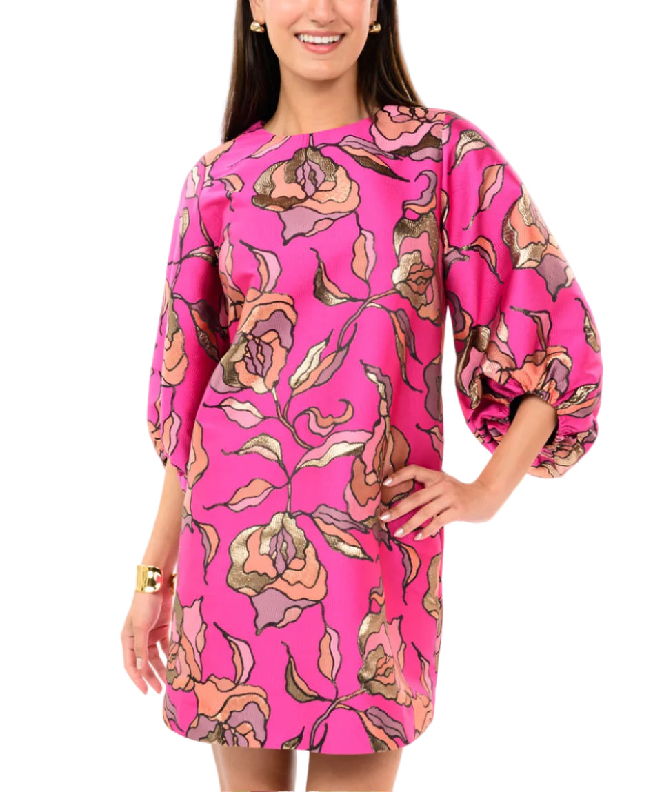 Woman wearing a pink dress with floral pattern on a white background