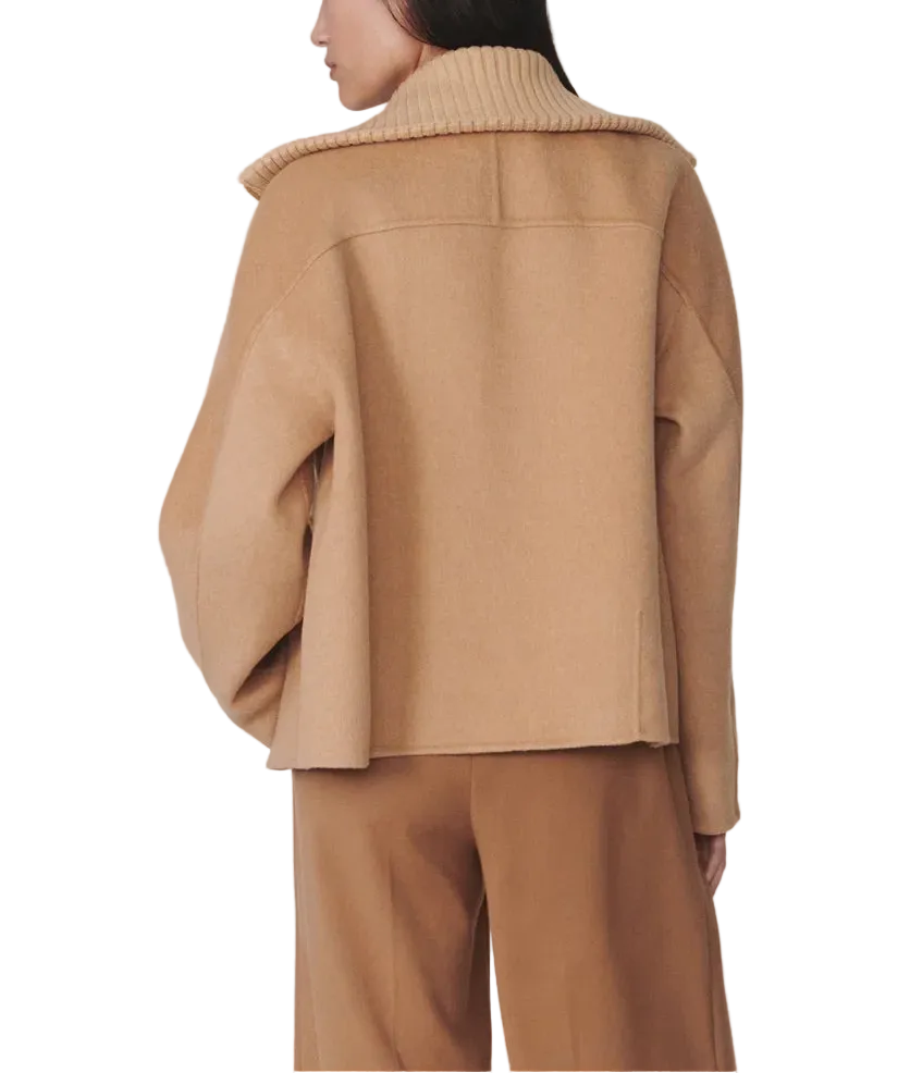 Person wearing a beige coat and pants on a plain background