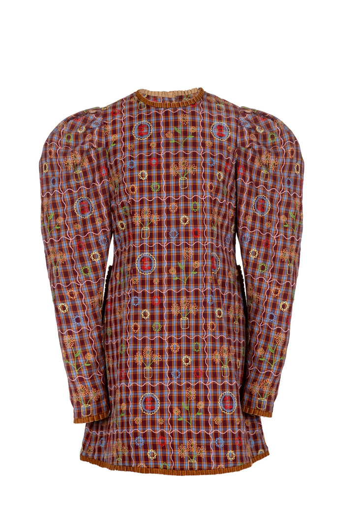 A long-sleeve puff-silhouette dress featuring an intricate multicolor plaid and geometric pattern in red, blue, yellow, and green, set against a plain white background.