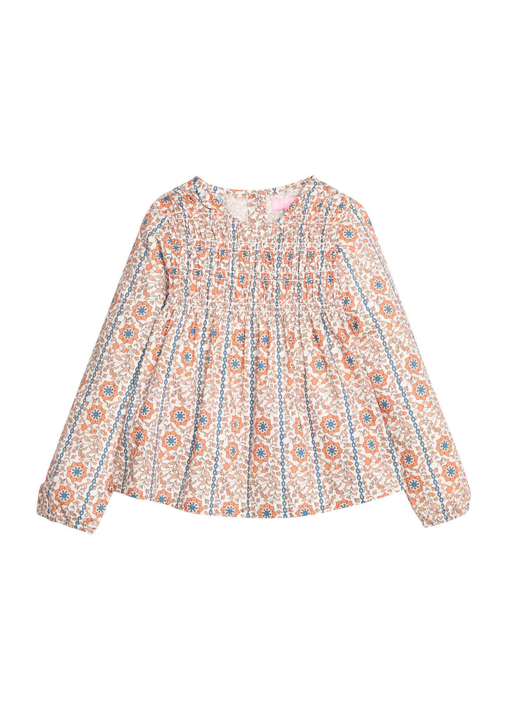 A long-sleeve smocked blouse with an intricate multicolor floral and geometric pattern on a cream base, featuring vertical smocked pleats at the bodice and cuffs.
