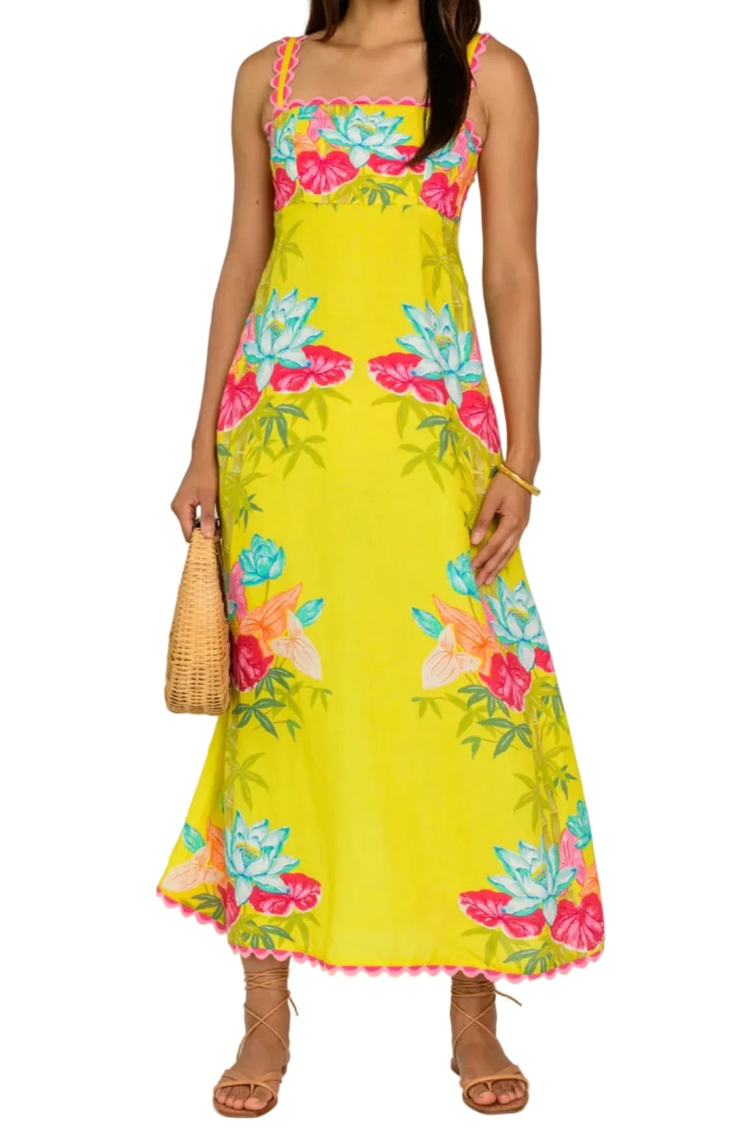 Woman wearing a yellow floral dress against a white background