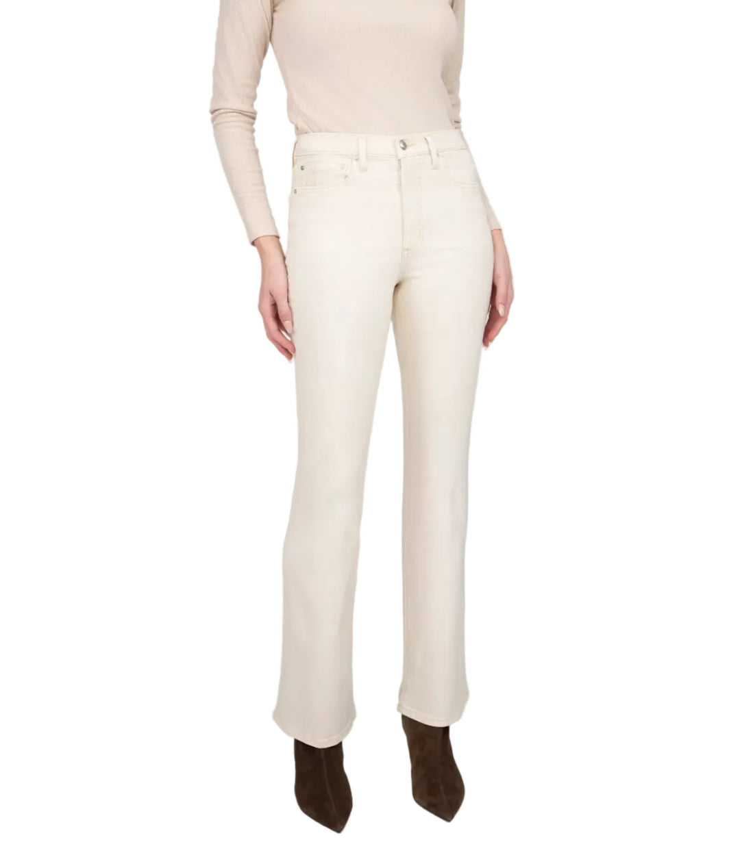A woman modeling a cream long-sleeve knit top and matching cream straight-leg jeans with dark brown pointed-toe ankle boots, standing against a light gray studio background.