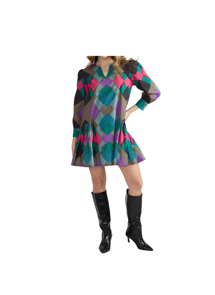 A playful split neckline and softly gathered shoulders set a breezy tone up top, while long cuffed sleeves and a relaxed body swing into a flirty drop-waist flounce at the hem. Slip on knee-high boots and let that twirl-worthy skirt do the talking.
