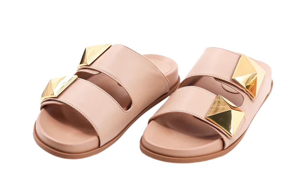 Step into elegance with our BERNARDA slides in smooth nude faux leather. Featuring wide straps and bold gold-tone studs, these sandals offer a chic, modern edge. With molded footbeds for comfort, they're the perfect stylish addition to your warm-weather wardrobe.
