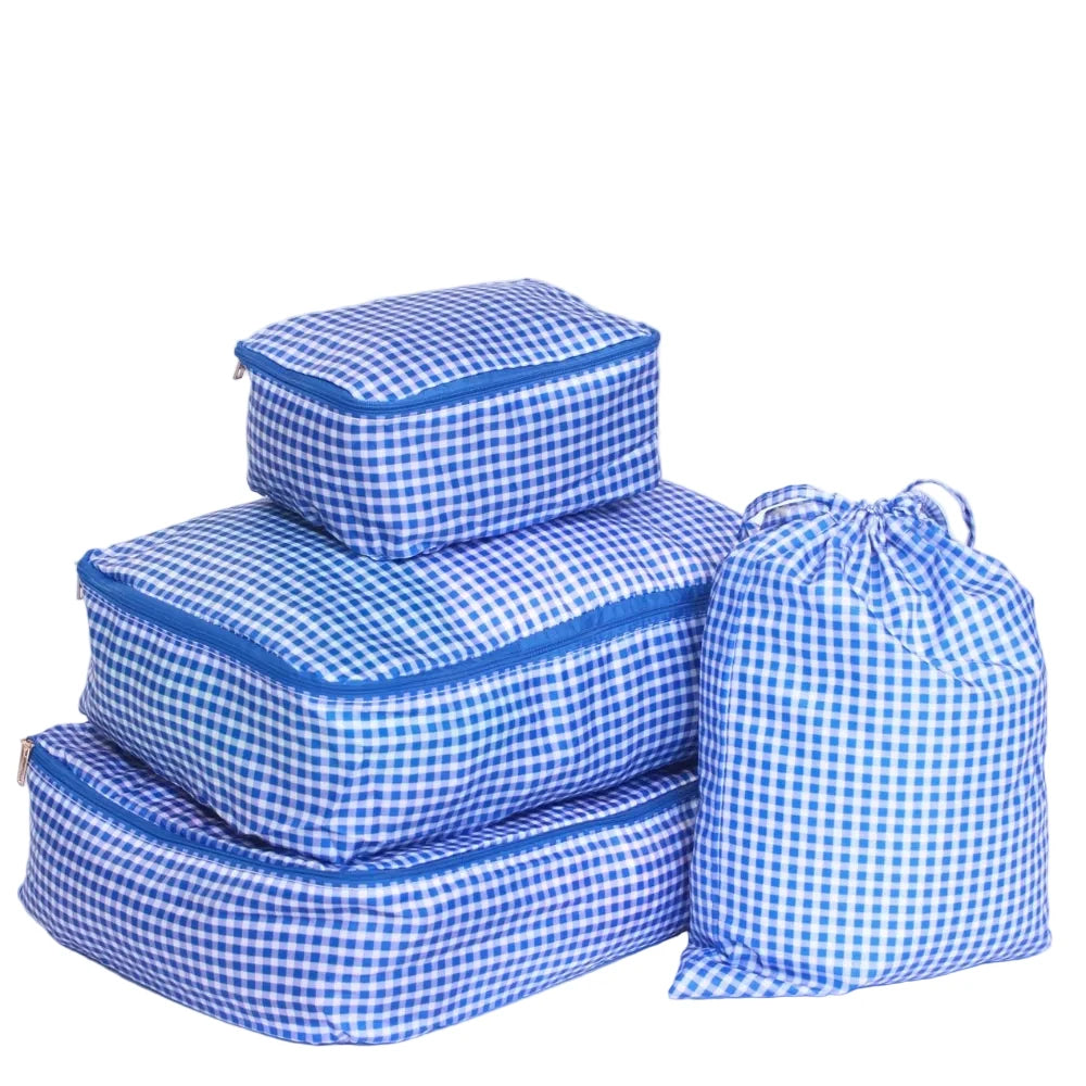 Set of blue and white checkered packing cubes on a light purple background