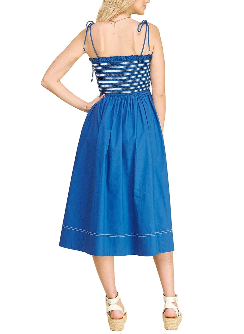 Woman wearing Blue midi dress with a smocked top with ties on the shoulder.