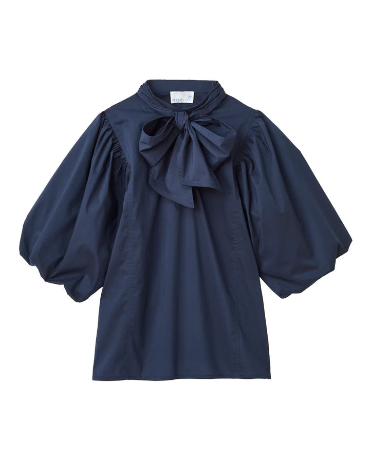 
The Perry Blouse in Midnight Blue—where sculpted sleeves meet soft cotton poplin, and every detail feels thoughtful. It’s the kind of piece that catches the light and lingers in memory.

Sculpted Volume: Puffed sleeves with a rounded bubble hem
Refined Touch: Slit neckline with adjustable closure and removable neck tie
Streamlined Shape: Breathable stretch cotton with a clean, tuckable fit