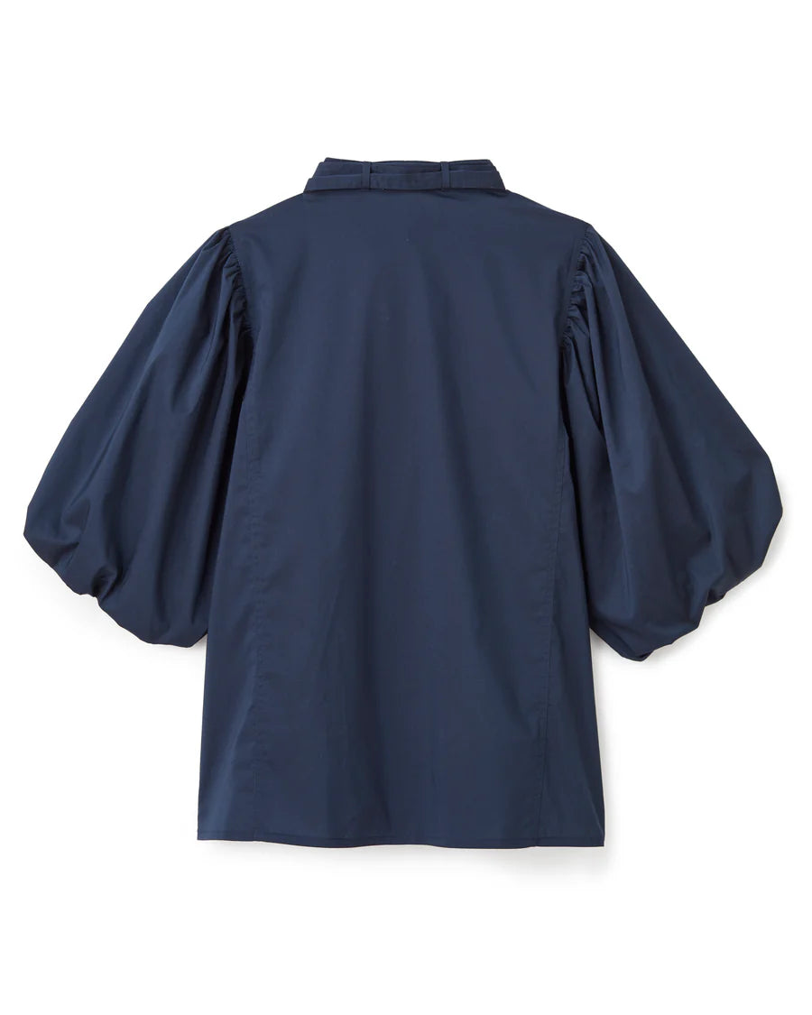
The Perry Blouse in Midnight Blue—where sculpted sleeves meet soft cotton poplin, and every detail feels thoughtful. It’s the kind of piece that catches the light and lingers in memory.

Sculpted Volume: Puffed sleeves with a rounded bubble hem
Refined Touch: Slit neckline with adjustable closure and removable neck tie
Streamlined Shape: Breathable stretch cotton with a clean, tuckable fit