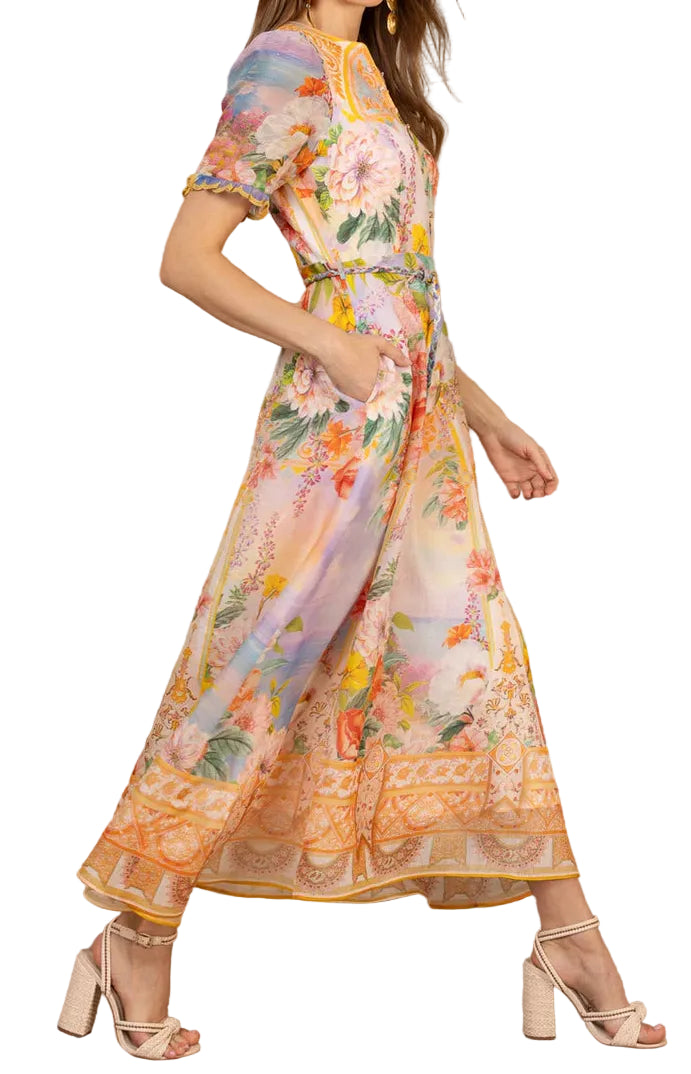 Woman wearing a colorful floral dress against a white background