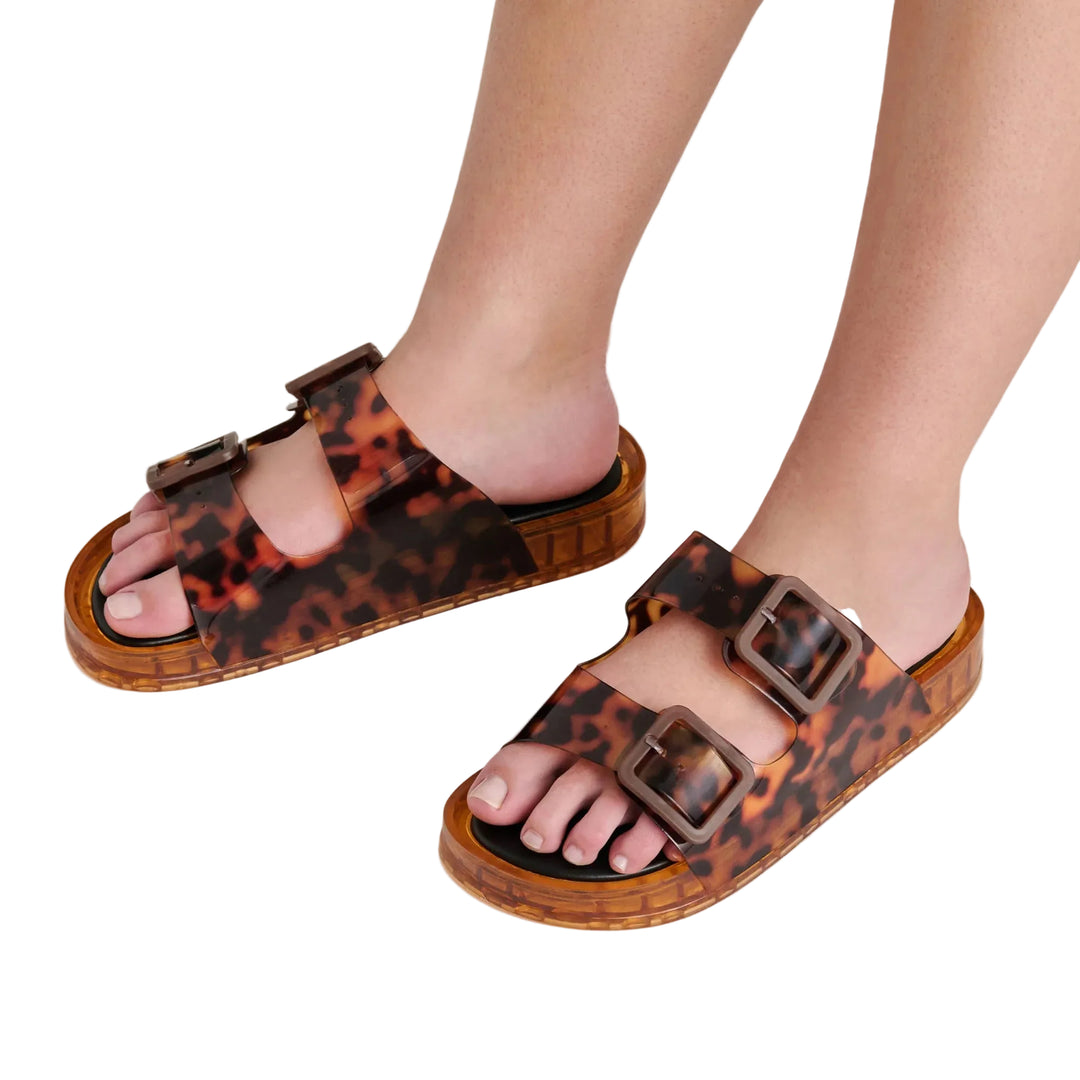 This favorite utilitarian sandal silhouette just got a 90s-inspired jelly makeover. JULIO makes a statement and prioritizes comfort with a contoured footbed, chunky sole, and adjustable straps fitted with oversized buckles all in translucent vinyl. Perfect for beach getaways, poolside lounging, or casual days out, this essential sandal is a playful and cool addition to cut off shorts and cover ups. 
